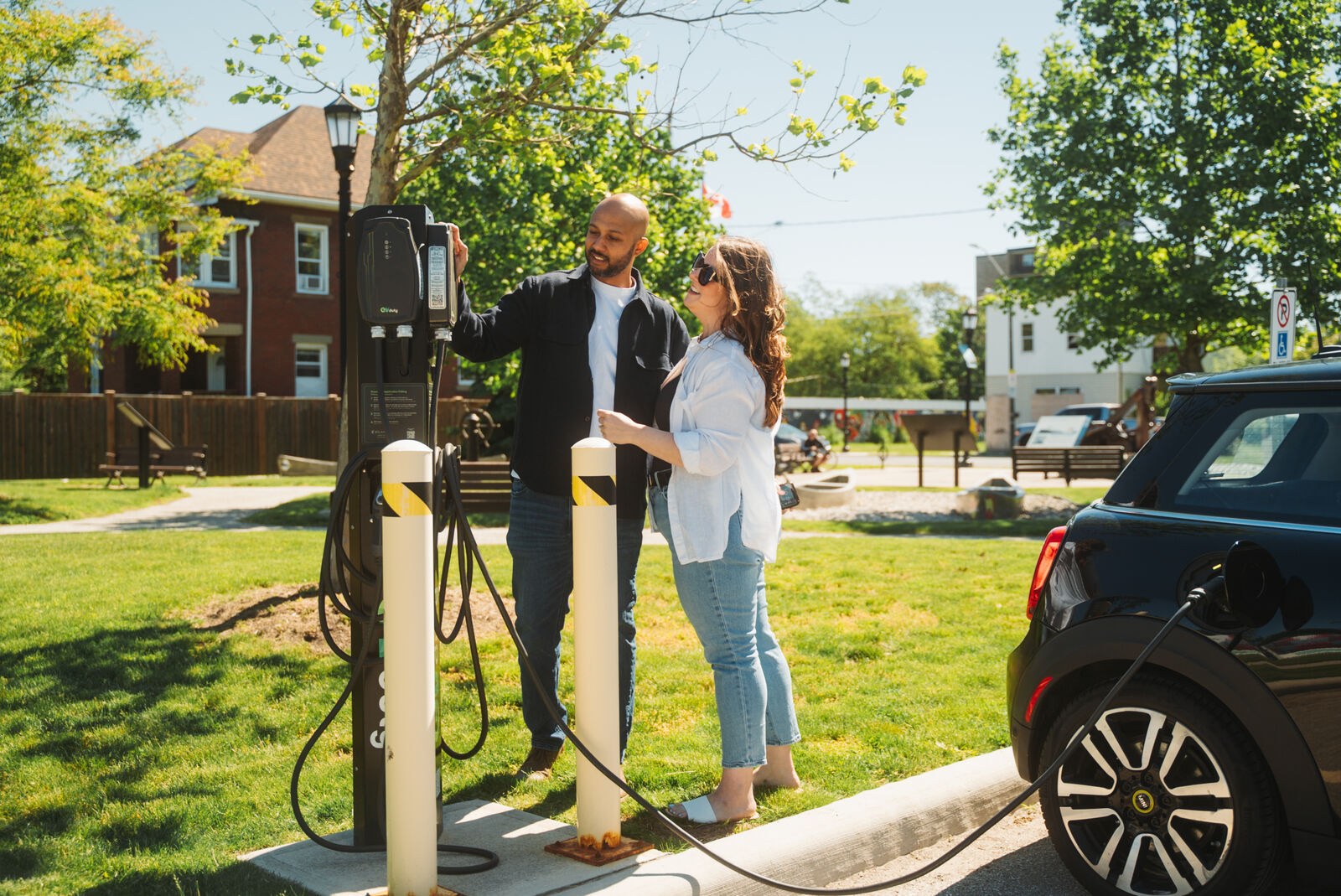 Team at EV charging station in green park space